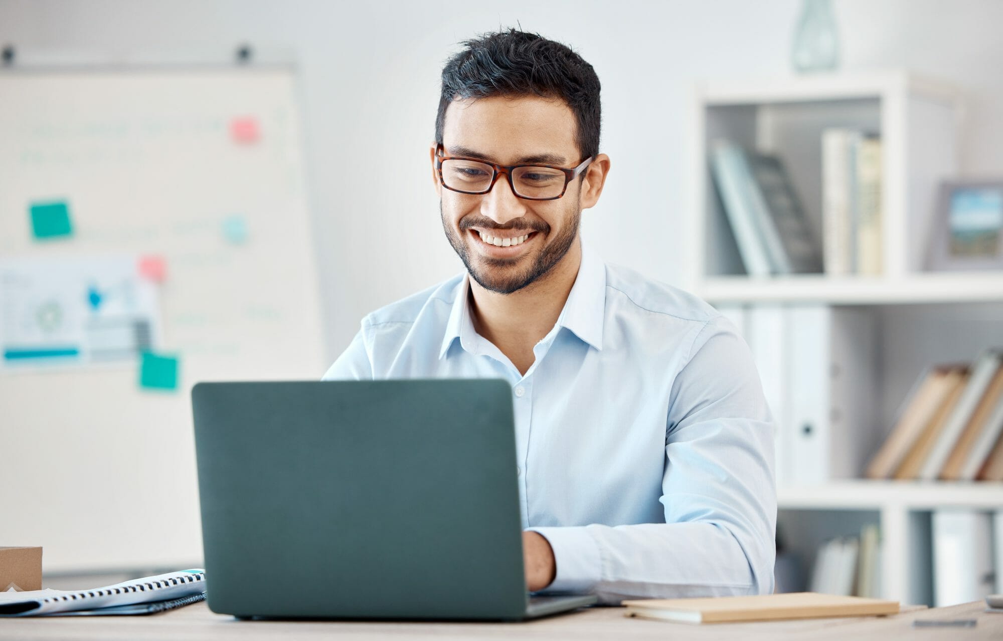 man smiling while working on laptop